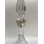 A cut glass decanter and stopper with silver collar.