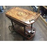 A decorative Italian Marquetry tea trolley with a brass gallery and brass wheels.no damage and in