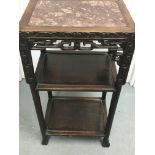 A Chinese hardwood occasion table the red marble top above two sections and carved surround.40 cm by