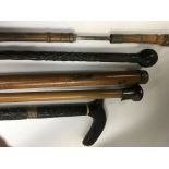 A bamboo sword stick and four other walking sticks