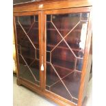 A Edwardian mahogany two door bookcase enclosing selfs on bracket feet 118 cm by 36 cm