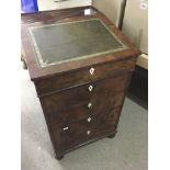 A Victorian flamed mahogany Davenport the sloping top above four drawers on bun feet