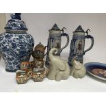 A collection of ceramics including two large steins and other ceramics.