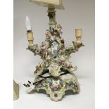An Early 20th century porcelain centre piece with raised figures and flowers converted to a lamp