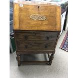 A small oak bureau with a fall front above two drawers