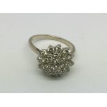 An 18ct white gold diamond cluster ring, approx 5.5g and approx size P.