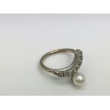 A white gold pearl and stone set ring. (E).