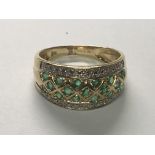 A decorative 14 carat emerald and diamond ring ring size O.