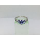A 14ct white gold ring set with three tanzanite stones and eight small diamonds, approx 3g and