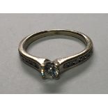 An 18carat gold ring set with a brilliant cut solitaire diamond the shank set with further diamonds,