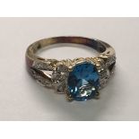 A 9carat gold ring set with a blue topaz and diamonds. ring Size O.