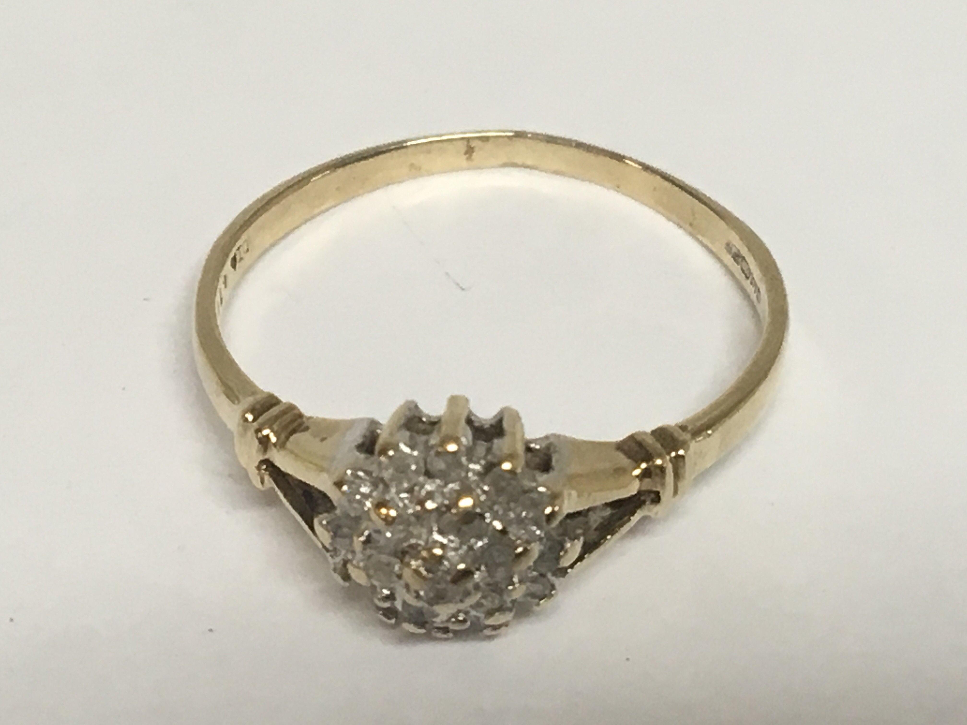 A 9carat gold ring set with a cluster of diamonds 0.10 of a carat ring size O-P