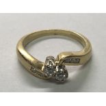 An 18carat yellow gold diamond two stone cross over ring the shank with further diamonds. Ring