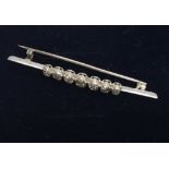 A 1930s platinum and old cut diamond set bar brooch. (Approx 4.9g)