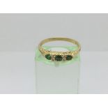 An 18ct gold ring set with three emeralds and four diamonds, approx 2.7g and approx size O-P.