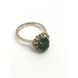 An 18ct white gold ring set with an emerald in diamond surround.Approx 5.30g, O.