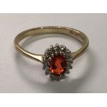 A 9carat gold ring inset with a red fire opal and small diamonds ring size N.