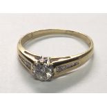 An 18carat gold ring set with a brilliant cut diamond approximately 0.33 of a carat flanked by