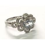 A white gold 9carat ring set with an aquamarine stone and diamonds.ring size P.