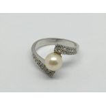 A 14ct gold ring set with a central pearl and thirty two small diamonds, approx 4.9g and approx size