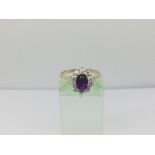 An 18ct gold ring set with a central amethyst and surrounded by ten diamonds, approx 3g and approx