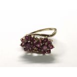 A 9carat gold ring set with a pattern of ruby coloured or heat treated stones Ring size K-L.