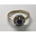 An 18carat gold ring set with a blue sapphire and diamond in a floral pattern. Ring size O