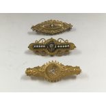 Three Edwardian gold brooches including 15 ct inset with diamond.