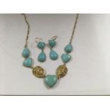 A 18 ct gold necklace and matching earrings inset with turquoise heart shape hard stone with