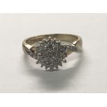 A 9carat gold diamond cluster ring with small diamonds set in the shank. Ring Size N.