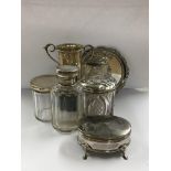 A collection of silver ware including tidy jars trophy cup and small trinket box .