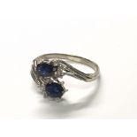 An 18carat white gold ring set with blue sapphire and diamonds ring size P. Shank slightly bent.