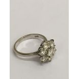 An 18ct white gold diamond cluster ring, brilliant cut stones with slight inclusions, approx size M