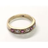 A 9carat gold ring set with alternating diamonds and rubies. Ring Size L-M