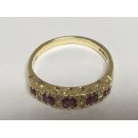 An 18carat gold ring set with a row of RubyÕs and small diamonds ring size K-L
