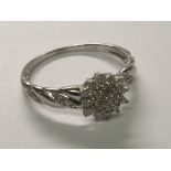 A 9cart gold ring set with a cluster of diamonds the shank with further chip stone diamonds. Ring