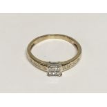 A 9carat gold ring set with a square pattern of Princess cut diamonds the shank with further