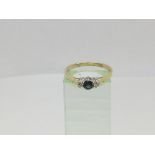 An 18ct gold ring set with a central sapphire and two diamonds, approx 2.3g and approx size R-S.