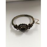 A Victorian bangle inset with garnets
