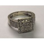 A 14carat white gold ring set with a square pattern of diamonds approximately one carat size L.