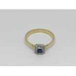 An 18ct gold ring set with a central sapphire surrounded by 12 small diamonds, approx 3.4g and