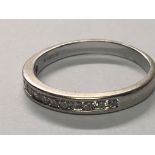 An 18carat white gold half hoop eternity ring set with a row of brilliant cut diamonds. ring size