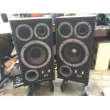 A pair of vintage Wharfedale E Fifty floor standing speakers, supplied with separate wheeled bases.