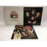 Three Queen LPs comprising'A Night At The Opera', 'Queen II' and 'Sheer Heart Attack'.