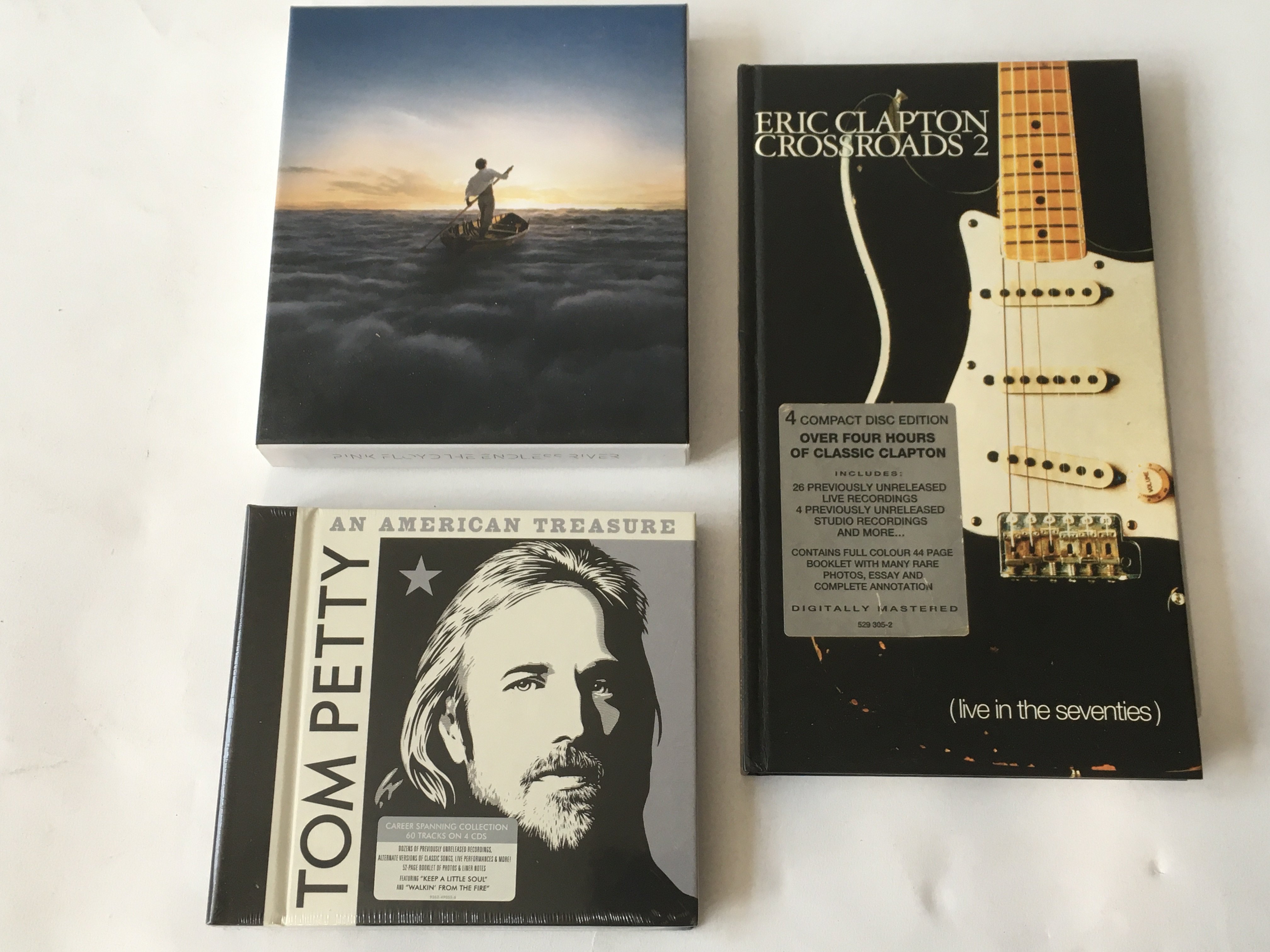 Three CD box sets comprising 'Endless River' by Pink Floyd, 'Crossroads 2' by Eric Clapton and 'An