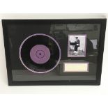 A framed and glazed Elvis Presley display containing a genuine signature and a rare 1956 UK 7 inch