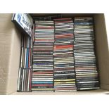 A box containing CDs and cassettes by various artists including The Beatles, Eagles, Fleetwood Mac