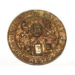 A pressed brass safe and lock makers plaque the centre with Royal Coat of Arms. Diameter 21cm