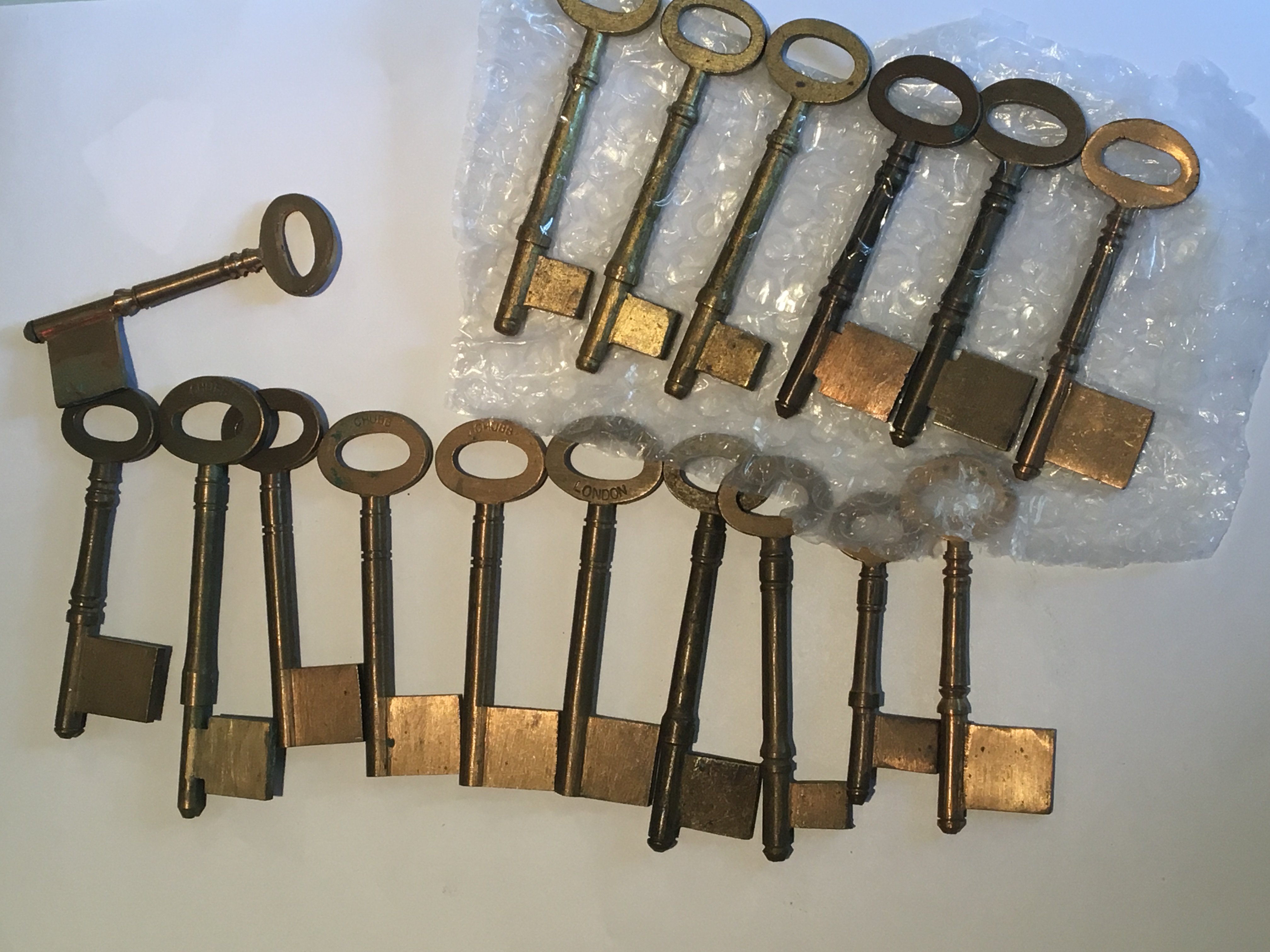 A collection of bronze and brass pin and pipe keys uncut some stamped by maker Chubb.