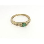 An 18carat gold ring set with a green emerald flan